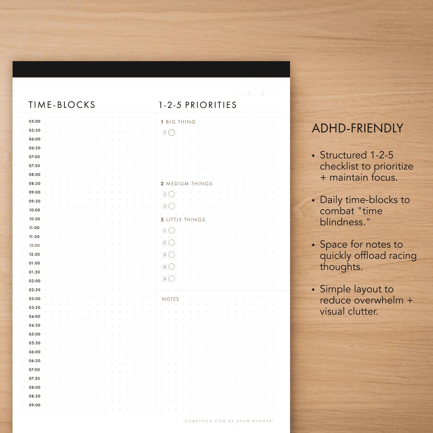 Notebook page with time blocks and priorities on a wooden surface
