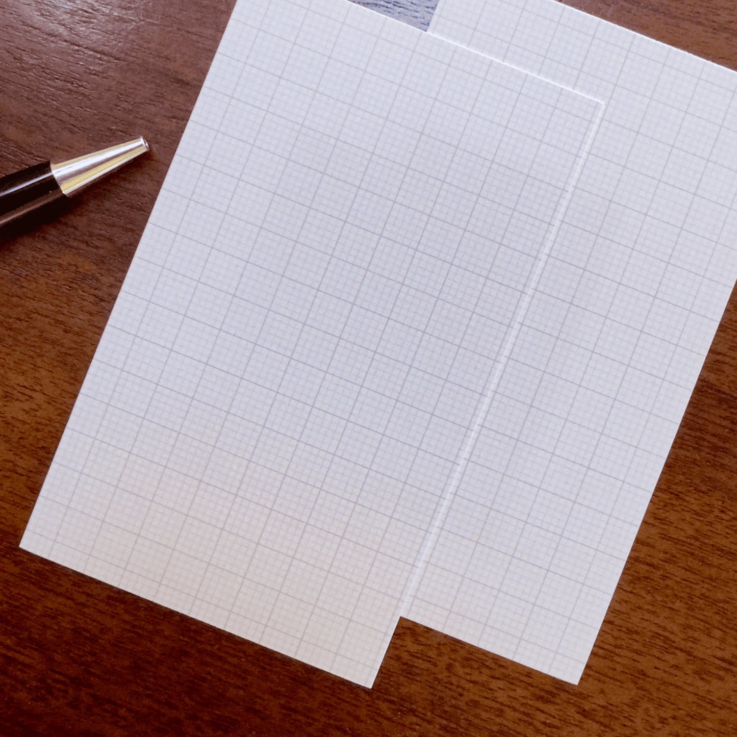 Two Capture Cards on a wooden surface with a pen.