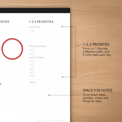 Time-blocking planner with priority system on a wooden surface