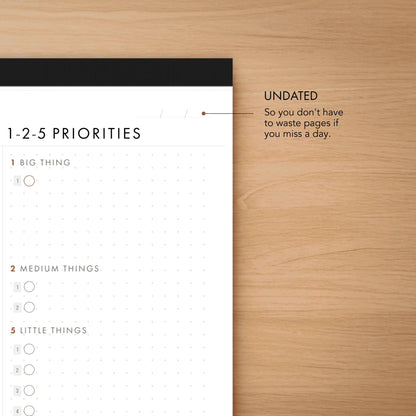 Time-blocks and priorities planner on a wooden surface
