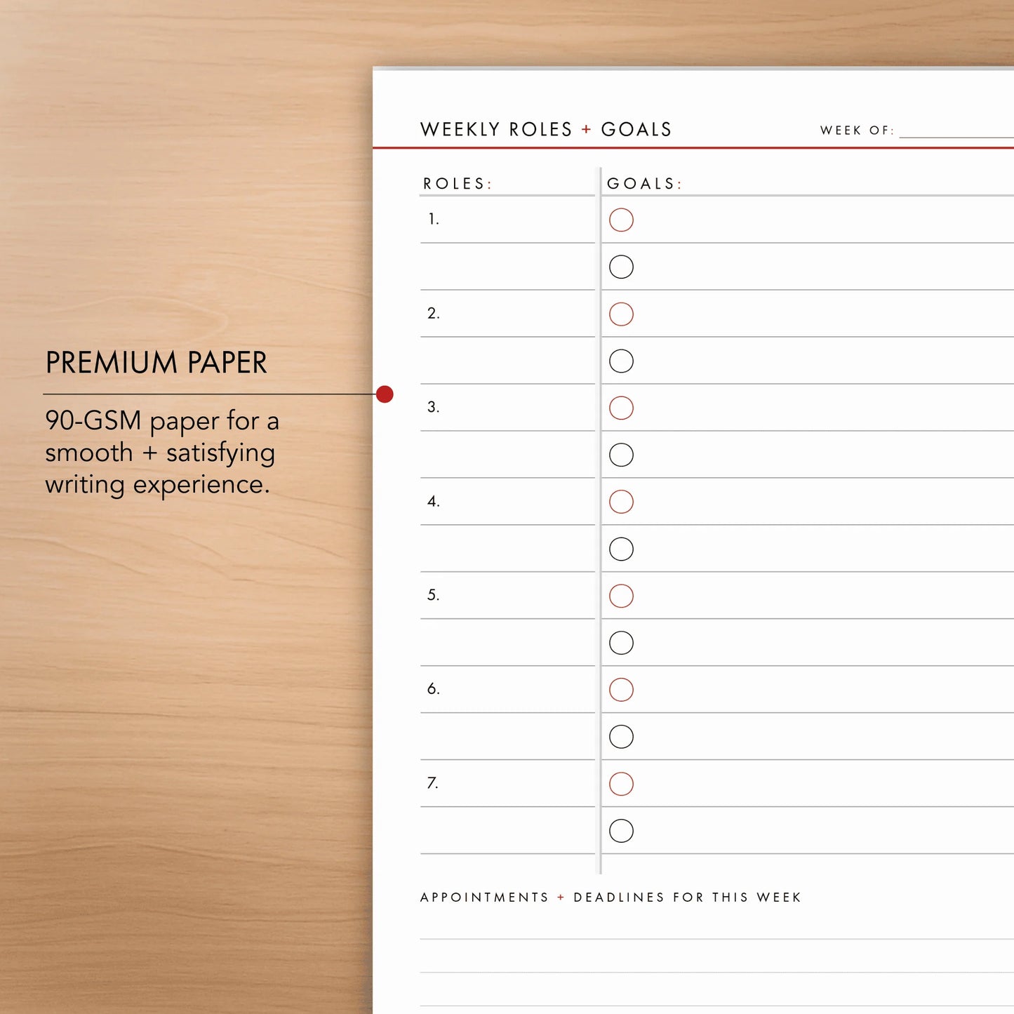 Weekly roles and goals planner sheet on a wooden surface with text about premium paper quality.