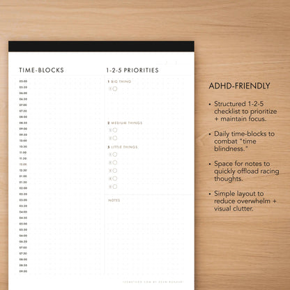 Notebook page with time blocks and priorities on a wooden surface